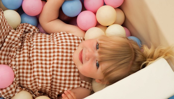 girl playing in a ball pit