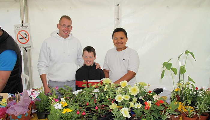 people standing next to their flower stall