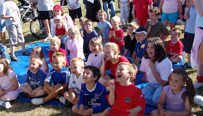group of children sitting on the grass laughing