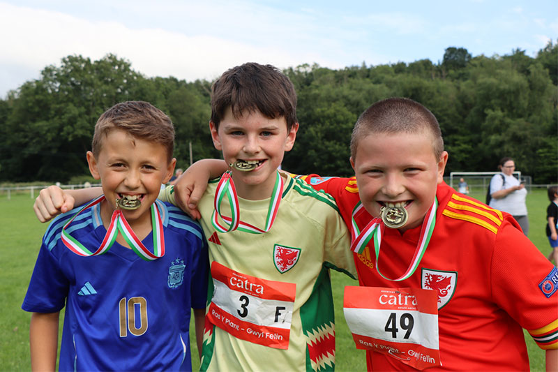 kids with medals in their mouths after participating in the kids race
